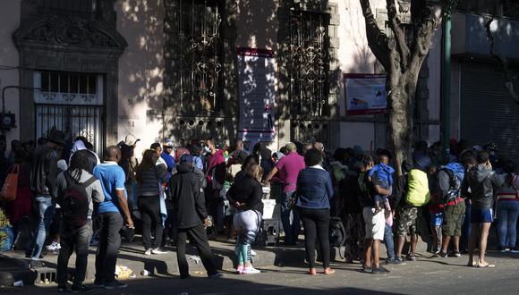 Migrantes hacen cola frente a la Comisión Mexicana de Atención a Refugiados (COMAR) en la Ciudad de México el 14 de marzo de 2023. (Foto referencial de CLAUDIO CRUZ / AFP)