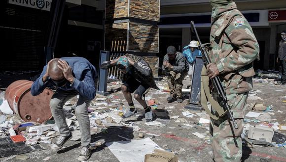 Soldados de la Fuerza de Defensa Nacional de Sudáfrica (SANDF) detienen a presuntos saqueadores en Jabulani Mall en Soweto el 13 de julio de 2021. (LUCA SOLA / AFP).