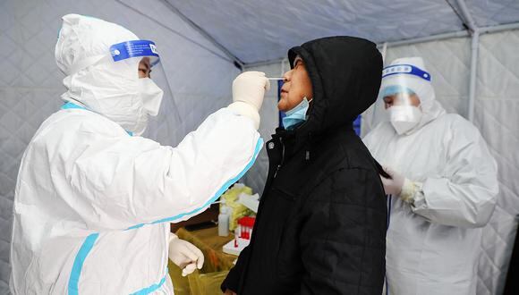 This photo taken on November 29, 2021 shows a resident undergoing a nucleic acid test for the Covid-19 coronavirus in Manzhouli in China's northern Inner Mongolia region. (Photo by CNS / AFP) / China OUT