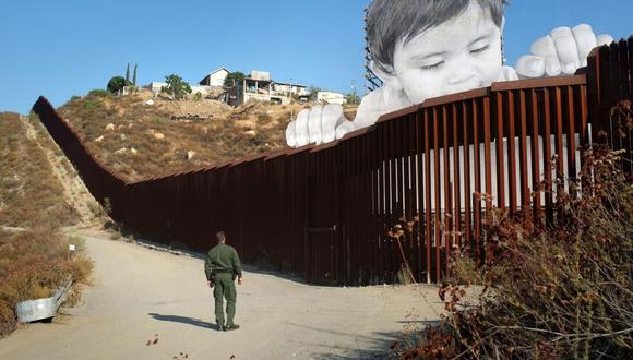 Un agente de la Patrulla Fronteriza estadounidense observa la obra "Kikito", del famoso artista y grafitero francés JR, en el muro que divide la frontera entre Tecate (Baja California, México) y San Diego (California, EE.UU.). (Foto: EFE)