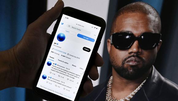 La cuenta de Twitter de Kanye West se muestra en un teléfono móvil con una foto de él de fondo el 28 de octubre de 2022 en Washington, DC. (Foto de OLIVIER DOULIERY / AFP)