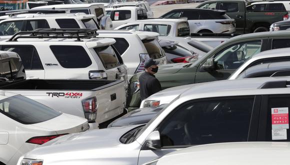Un funcionario de Investigaciones de Seguridad Nacional camina entre vehículos por un valor estimado de 3,2 millones de dólares en Port Everglades después de que fueron incautados en Fort Lauderdale, Florida. Los vehículos iban a ser enviados a Venezuela en violación de las leyes y sanciones de exportación de Estados Unidos. (AP Foto/Lynne Sladky).