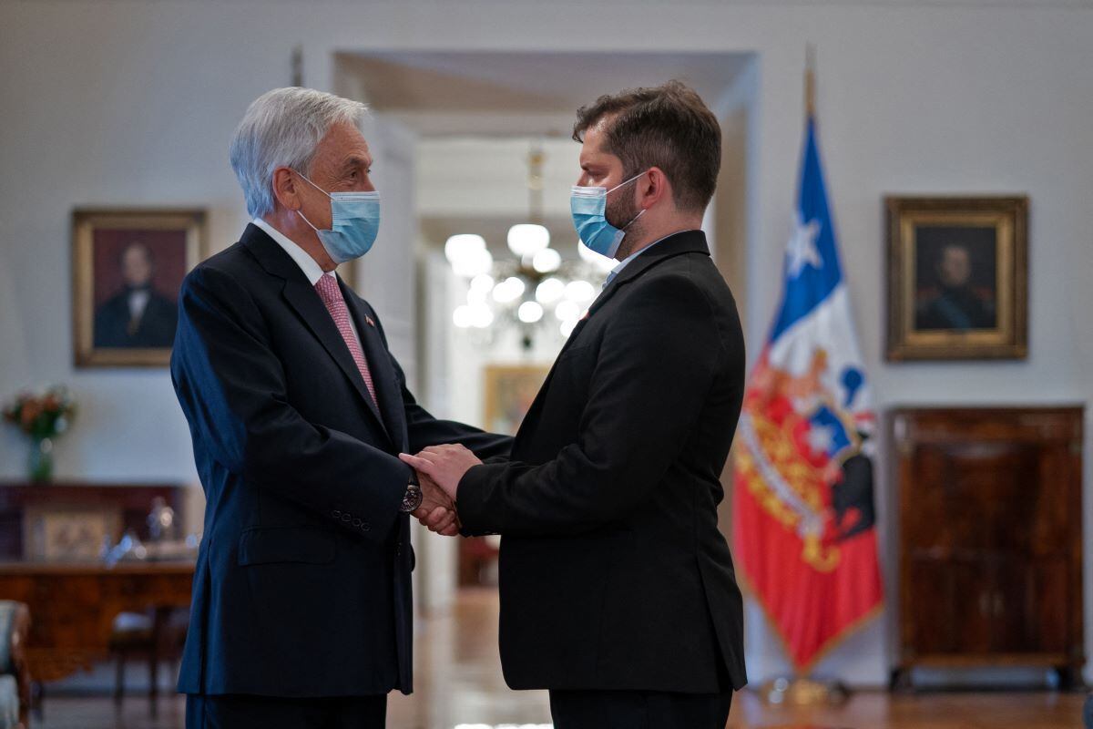 The elected president of Chile, Gabriel Boric (right), shakes the hand of President Sebastián Piñera, during a meeting at the presidential palace of La Moneda, on December 20, 2021. (Photo: AFP).