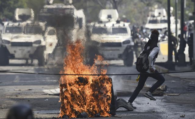 La Guardia Nacional arrojó gases lacrimógenos contra cientos de personas que intentaban bloquear una autopista en proximidades de la base aérea La Carlota, donde un grupo de militares se sublevó contra Nicolás Maduro. (AFP).