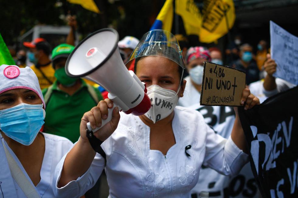"SOS. Vacunas ya", decía este sábado uno de los carteles en una protesta de médicos y enfermeras en Venezuela en exigencia de vacunas contra el coronavirus, movilización acompañada por dirigentes políticos y activistas de oposición. (Texto y foto: AFP).