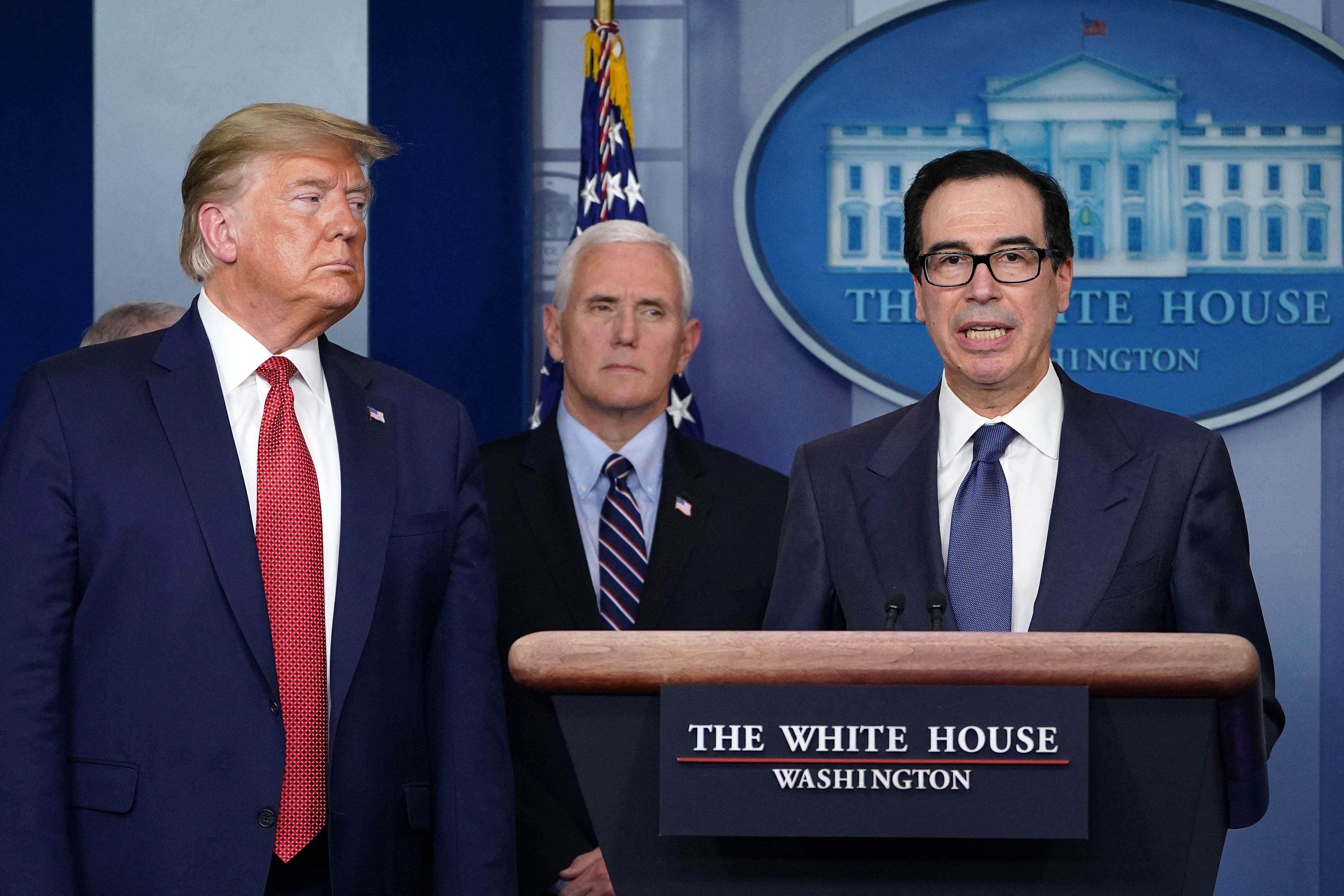 Then-U.S. Treasury Secretary Steven Mnuchin speaks during a press conference about the COVID-19 coronavirus outbreak as President Donald Trump looks on.  (Photo by MANDEL NGAN/AFP).
