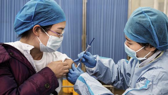 Un miembro del personal médico (izquierda) recibe una inyección de refuerzo de la vacuna contra el coronavirus Sinopharm Covid-19 en un hospital de Wuhan en la provincia central de Hubei en China. (Foto de AFP / China).