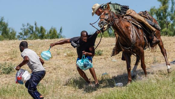 Un agente de la Patrulla Fronteriza de Estados Unidos a caballo intenta evitar que un migrante haitiano ingrese a un campamento a orillas del Río Grande, cerca del Puente Internacional Acuña del Río en Del Río, Texas, el 19 de septiembre de 2021. (PAUL RATJE / AFP).