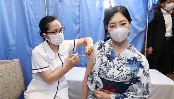 Una artista de performance recibe la vacuna contra el coronavirus durante la campaña de vacunación en el lugar de trabajo de la Asociación Turística Arima Onsen en Kobe, prefectura de Hyogo, Japón. (STR / JIJI PRESS / AFP).