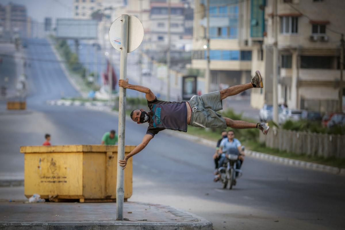 Imagen de un joven en medio de un encierro por el nuevo coronavirus en la ciudad de Gaza. (AFP / MOHAMMED ABED).