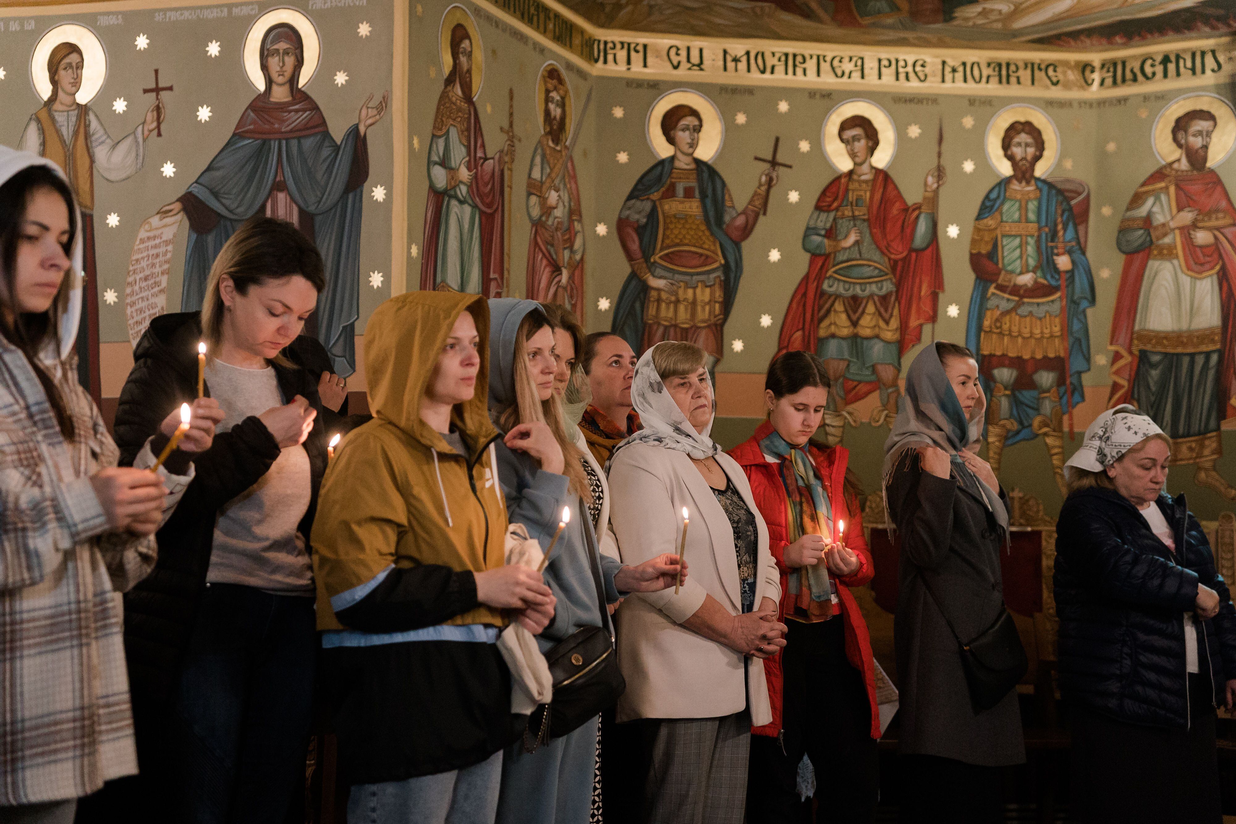 Ukrainian refugees attend a church service in Bucharest, Romania, to celebrate Orthodox Easter.  PHOTO: Andrei Pungovschi/Bloomberg