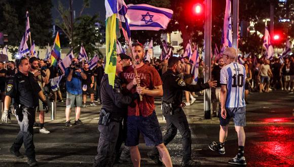 Un manifestante es retenido por un policía antidisturbios israelí durante una manifestación de protesta contra el plan de reforma judicial del gobierno israelí en Tel Aviv. (Foto de JACK GUEZ / AFP)