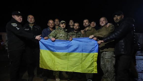 Prisioneros de guerra ucranianos posando con una bandera ucraniana después de su intercambio en la región de Chernigiv.  (Foto de Handout / SERVICIO DE SEGURIDAD DE UCRANIA / AFP)