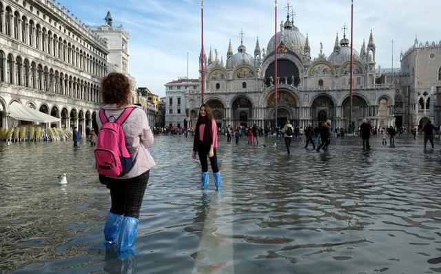 Los turistas se toman fotos en la Plaza de San Marcos después de días de graves inundaciones en Venecia. (REUTERS / Manuel Silvestri).