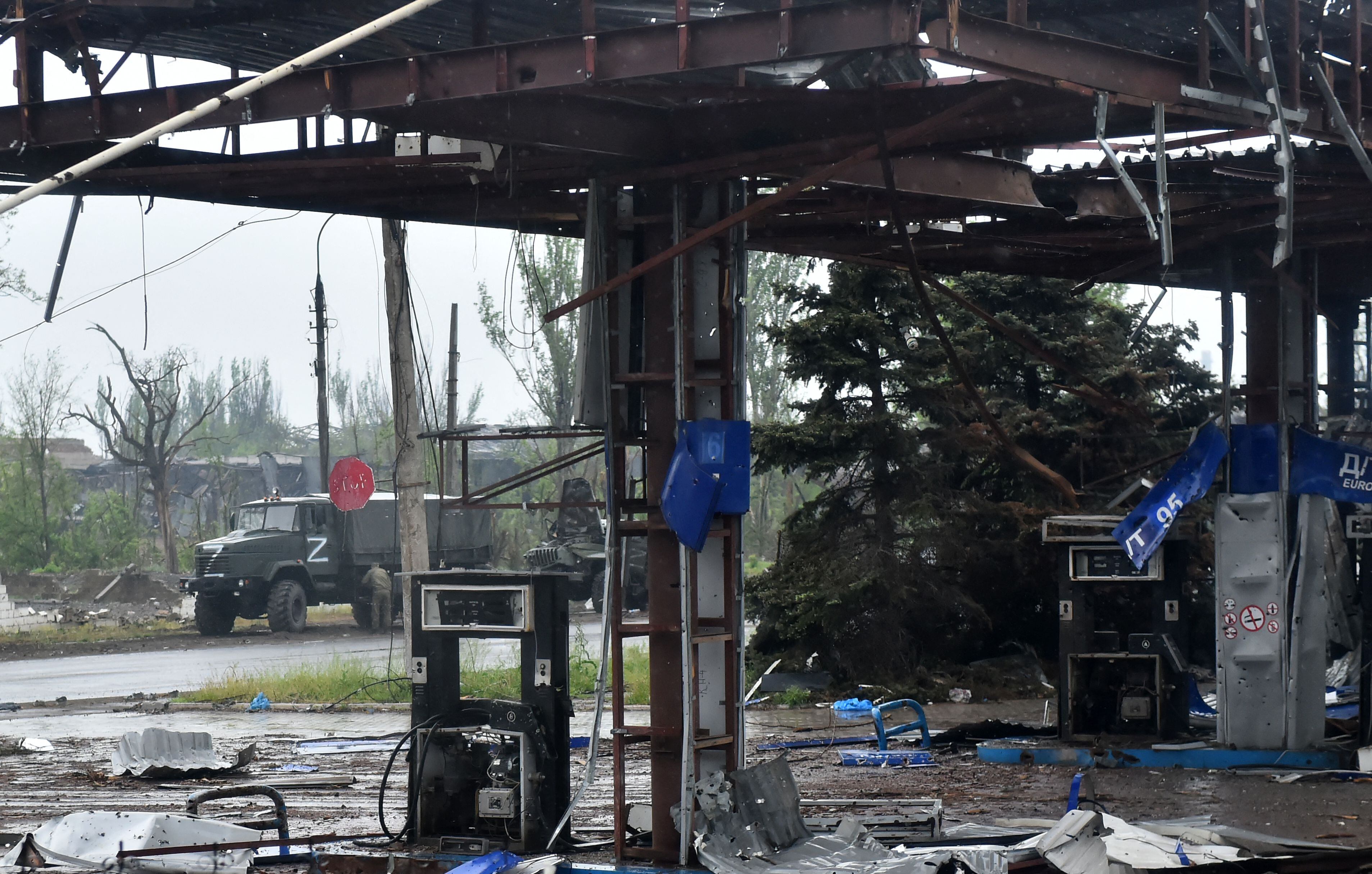 A Russian military truck painted with the letter Z is seen behind a destroyed gas station in the port city of Mariupol, Ukraine amid ongoing Russian military action in Ukraine.