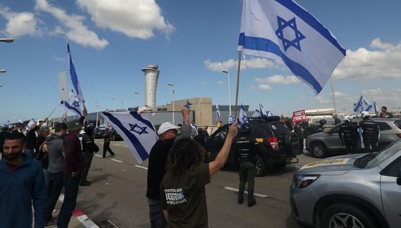 Los israelíes que protestan contra el controvertido proyecto de ley de reforma judicial del gobierno y bloquean la carretera principal que conduce al aeropuerto Ben Gurion, cerca de Tel Aviv. (Foto de AHMAD GHARABLI / AFP).
