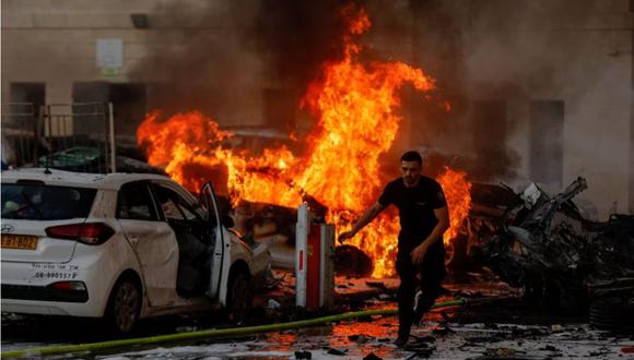 Un hombre corre mientras el fuego arde después del lanzamiento de cohetes desde la Franja de Gaza, en Ashkelon, Israel, el 7 de octubre de 2023. (REUTERS/Amir Cohen).