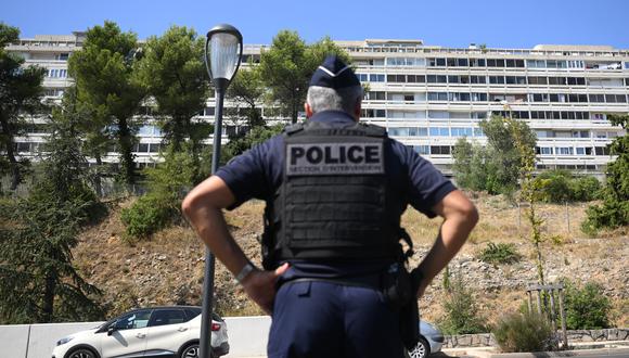 Un oficial de policía francés hace guardia en el popular barrio de Pissevin en Nimes, sur de Francia, el 22 de agosto de 2023, después de que un niño de 10 años muriera en un tiroteo. (Foto de NICOLAS TUCAT / AFP)