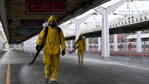Militares del Ministerio de Emergencias de Rusia que usan equipo de protección desinfectan la estación de tren Leningradsky de Moscú el 19 de octubre de 2021, en medio de la pandemia de coronavirus. (Kirill KUDRYAVTSEV / AFP).