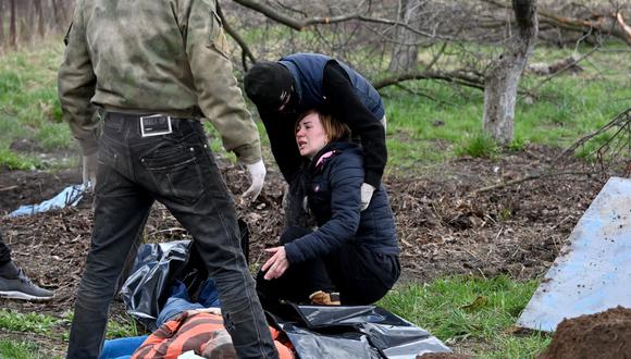 La esposa de un civil reacciona después de que su cuerpo fuera exhumado de una fosa común cerca de su casa en el pueblo de Andriivka, región de Kiev, el 11 de abril de 2022. (Foto referencial, Sergei SUPINSKY / AFP).