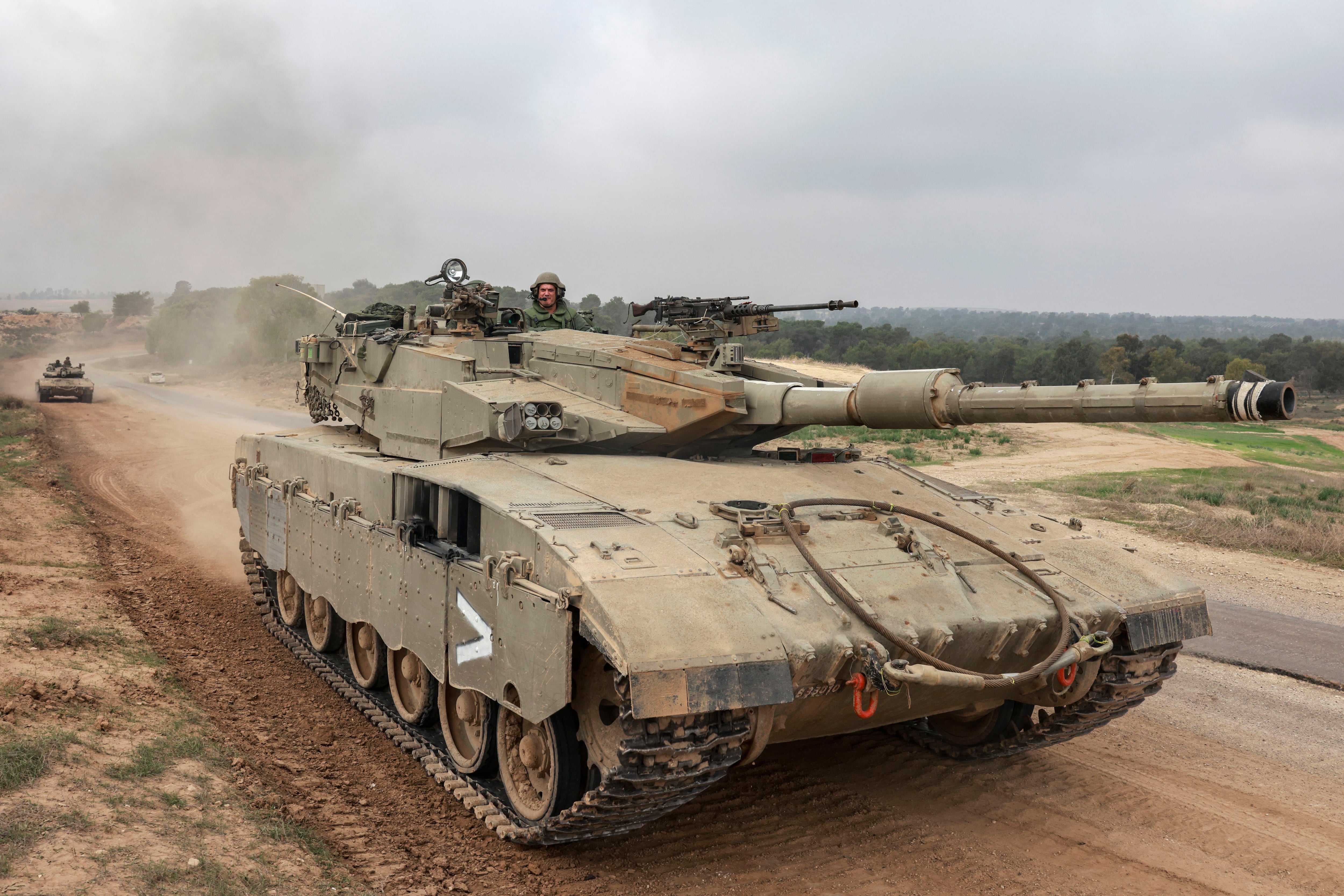 Israeli military tanks near the border with the Gaza Strip on December 5, 2023. (Photo by Menahem KAHANA/AFP).