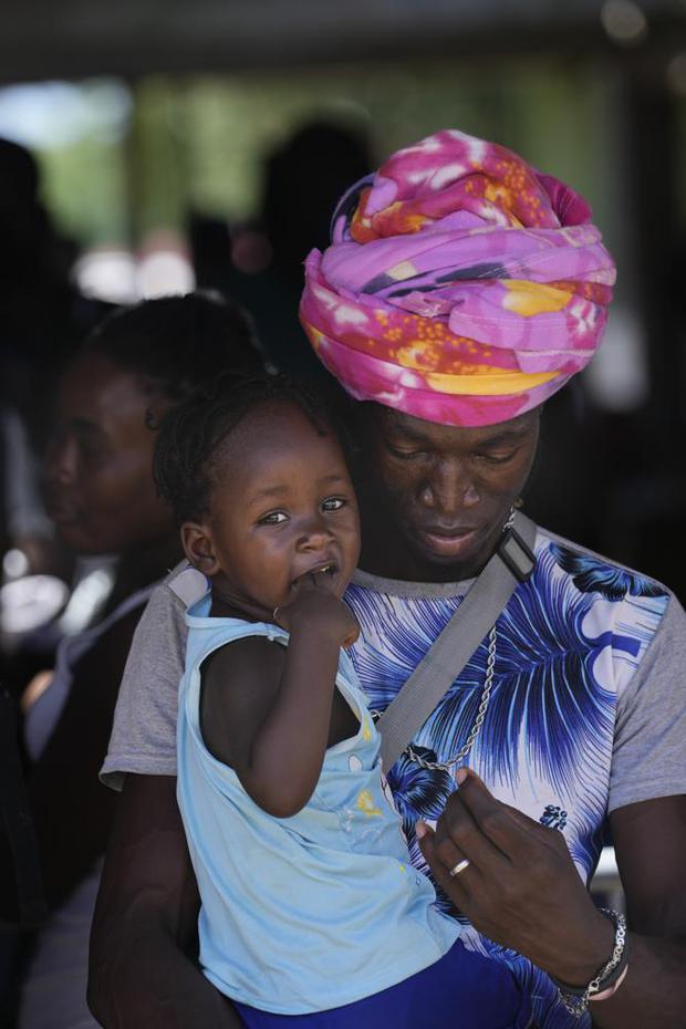 Migrantes, muchos de ellos de Haití, hacen fila para abordar un autobús que los trasladará a otro refugio en su viaje por Panamá, tratando de llegar a Estados Unidos, en Lajas Blancas, provincia de Darién, Panamá, el viernes 1 de octubre de 2021. (Foto AP/Arnulfo Franco).