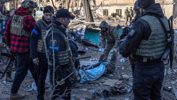 Militares y policías ucranianos junto al cadáver de una persona muerta tras un bombardeo del ejército ruso, en el distrito de Podilskyi, de Kyiv (Kiev), Ucrania. (Foto: EFE/EPA/ROMAN PILIPEY).