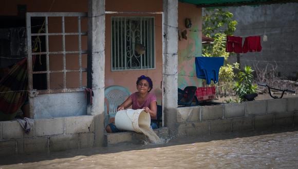 Una mujer usa un balde para sacar agua de su casa inundada en la ciudad de La Fortuna en el estado de Zulia, Venezuela. (Foto: Federico PARRA / AFP)