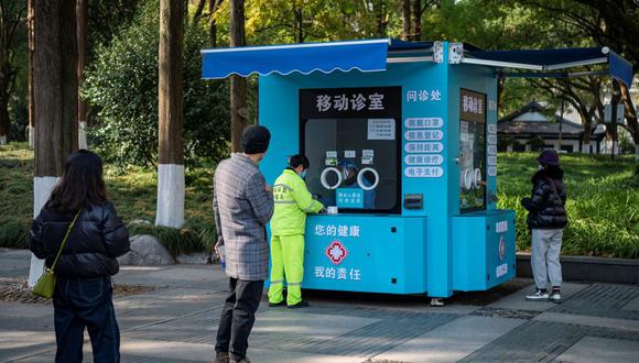 Un trabajador con un traje protector espera a que las personas tomen muestras de hisopos para analizar la enfermedad del coronavirus en Shanghái, China, el 22 de diciembre de 2022. (REUTERS/Aly Song).