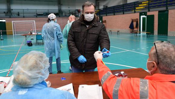 Personas de la ciudad de Robbio, en el norte de Italia, llegan al pabellón deportivo para hacerse análisis de sangre para COVID-19. (Foto: Miguel Medina / AFP)