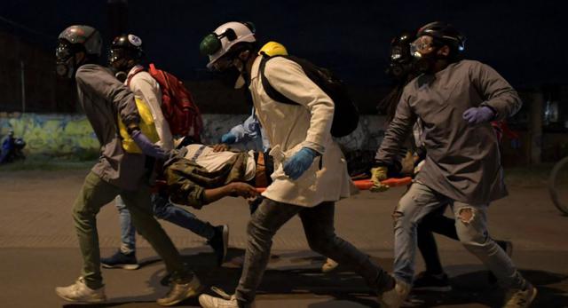 Voluntarios cargan en camilla a un manifestante herido durante enfrentamientos con la policía antidisturbios en protesta contra el gobierno del presidente colombiano Iván Duque, en la estación terminal Portal De Las Américas, en Bogotá. (Raúl ARBOLEDA / AFP)