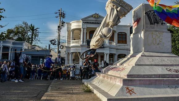 Los manifestantes derriban una estatua de Cristóbal Colón durante una manifestación contra el gobierno en Barranquilla, Colombia, el 28 de junio de 2021. (Mery Grandos Herrera / AFP).