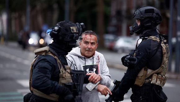 Un oficial de policía de la unidad RAID ayuda a un hombre herido durante las protestas en Lille, en el norte de Francia, el 29 de junio de 2023, dos días después de que un adolescente fuera asesinado a tiros en Nanterre. (Foto de KENZO TRIBOUILLARD / AFP)