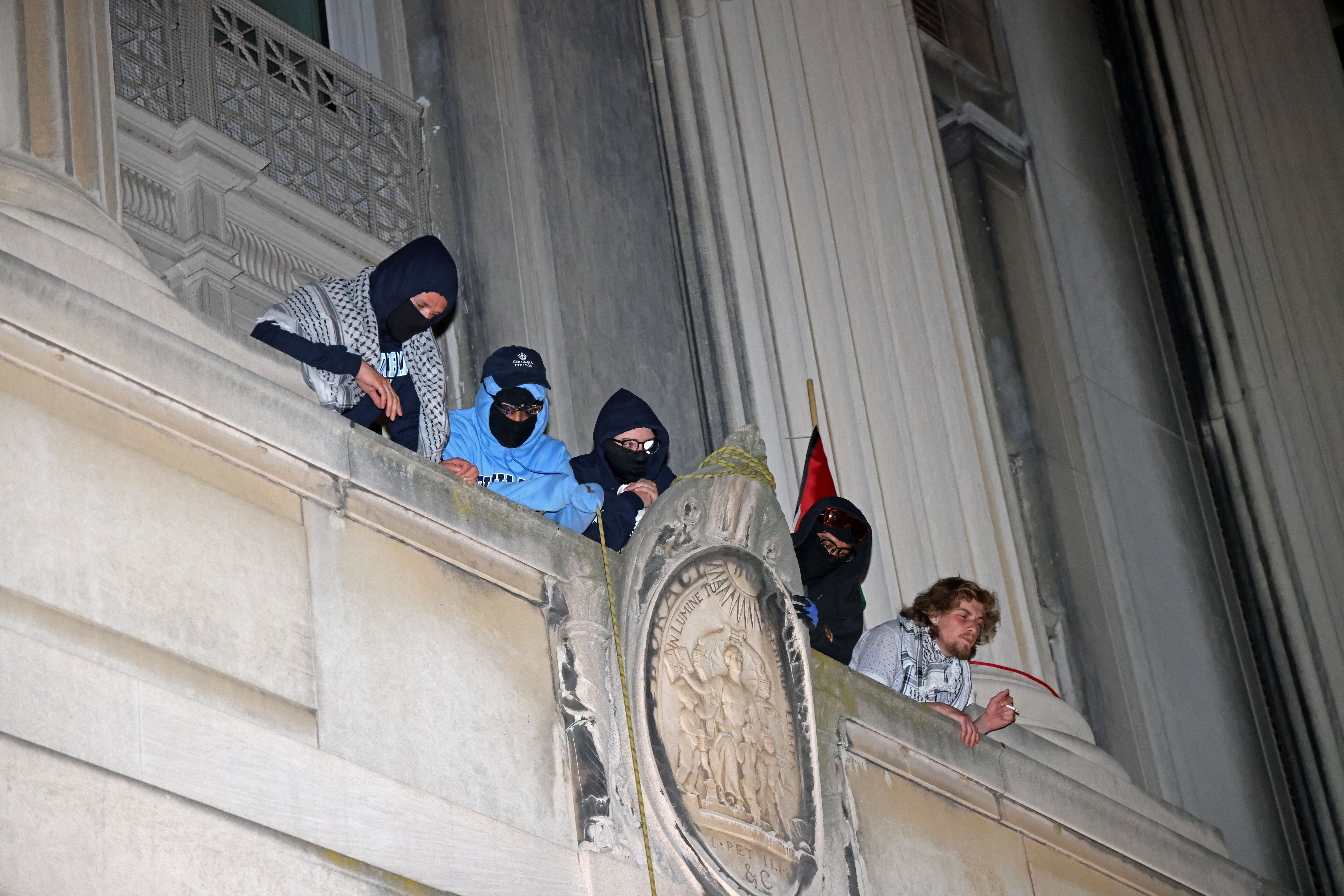 Estudiantes manifestantes pro palestinos observan desde un balcón de Hamilton Hall en el campus de la Universidad de Columbia, el 30 de abril de 2024, en la ciudad de Nueva York. (Foto de Jia Wu / AFP)