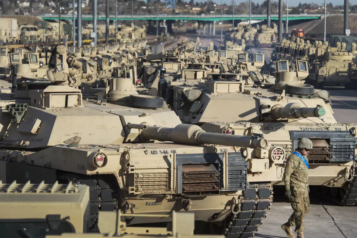 A soldier walks past a line of M1 Abrams tanks on November 29, 2016 at Fort Carson in Colorado Springs, USA.  (Christian Murdock/The Gazette via AP, File)