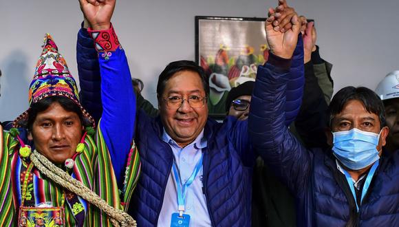 Luis Arce (centro), del partido Movimiento por el Socialismo, celebra con su compañero de fórmula David Choquehuanca (derecha) su triunfo en las elecciones en Bolivia. (Foto de RONALDO SCHEMIDT / AFP).