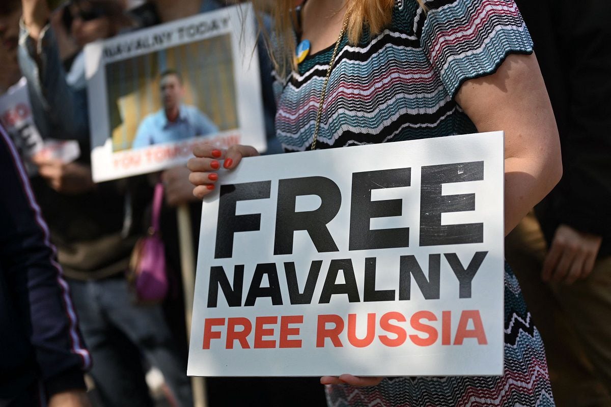 A protester holds placards at a rally outside the Russian embassy in support of jailed Kremlin critic Alexei Navalny, in London on June 4, 2023, to mark Alexei Navalny's 47th birthday.  (Photo by JUSTIN TALLIS / AFP)