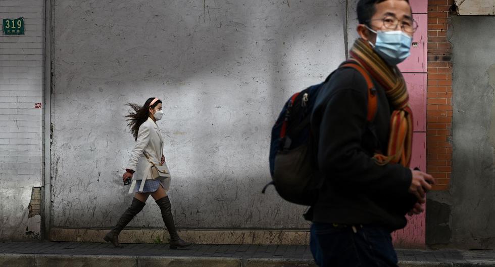 Personas usan máscaras faciales protectoras mientras caminan a sus centros de labores por una calle en Shanghai. El número de muertos por la nueva epidemia de coronavirus de China aumentó a 1.770, según los últimos reportes. (AFP)