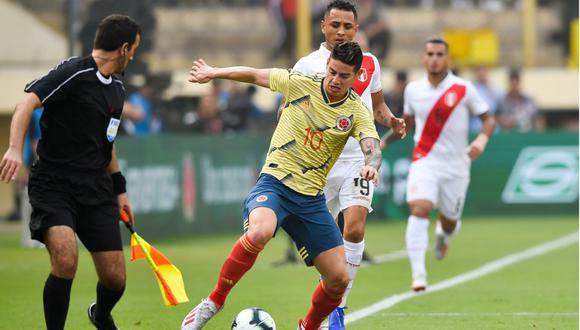 James Rodríguez controlando una pelota, mientras es perseguido por Yoshimar Yotún. (Foto: AFP)