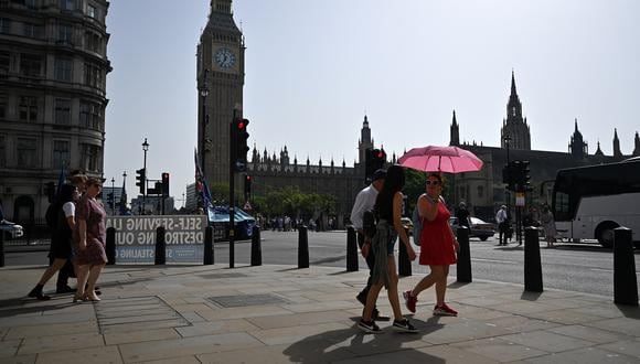 Peatones caminan bajo el sol del mediodía frente al Palacio de Westminster en el centro de Londres el 6 de septiembre de 2023 mientras continúa la ola de calor de finales del verano. (Foto de JUSTIN TALLIS / AFP)