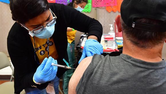 La enfermera registrada Mariam Salaam administra la inyección de refuerzo de Pfizer en un sitio de vacunación y prueba de Covid, en Ted Watkins Park en Los Ángeles el 5 de mayo de 2022. (Foto de Frederic J. BROWN / AFP)