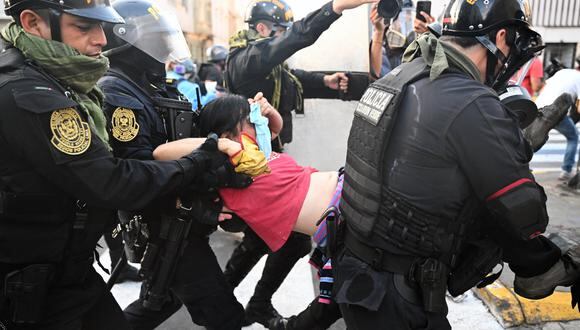 La policía antidisturbios lleva a un manifestante afectado por gases lacrimógenos durante una protesta contra el gobierno de Dina Boluarte pidiendo su renuncia y el cierre del Congreso, en Lima el 24 de enero de 2023. (Foto por ERNESTO BENAVIDES / AFP)