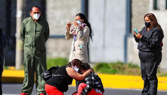 Familiares de pacientes diagnosticados con la COVID-19 esperan información en el hospital del Iess, en Quito (Ecuador). (EFE/José Jácome).