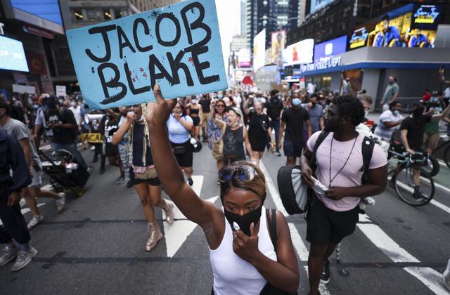La gente marcha por Times Square durante una protesta en respuesta al tiroteo del 23 de agosto por parte de policías en Kenosha, Wisconsin, de Jacob Blake. (EFE/JUSTIN LANE).