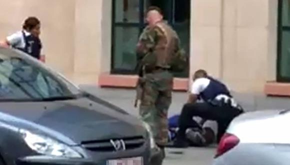Un soldado junto a unos policías rodean a un sujeto que yace en el suelo en el lugar donde dos soldados fueron atacados en el centro de Bruselas, Bélgica. (Foto: AFP)