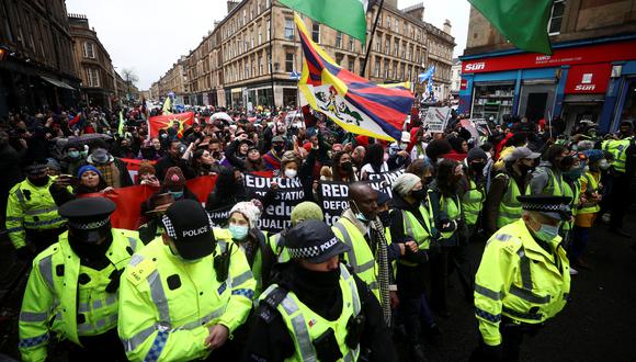 Protestas de hoy sábado en Glasgow. Policías acompañan a los manifestantes que reclaman acuerdos en la COP26. REUTERS