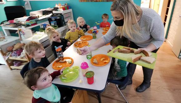 Amy McCoy sirve el almuerzo a los niños que cuida en la guardería Forever Young Daycare de Mountlake Terrace (estado de Washington) el 25 de octubre del 2021. (AP Photo/Elaine Thompson).