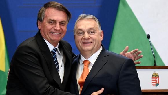 El primer ministro de Hungría, Viktor Orban (derecha), y el presidente de Brasil, Jair Bolsonaro, se abrazan después de dar una conferencia de prensa conjunta el 17 de febrero de 2022 en Budapest, Hungría. (Foto de Atila KISBENEDEK / AFP)