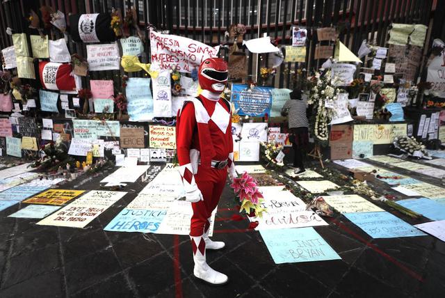 Un joven disfrazado de “Power Ranger” deja flores en el lugar donde se rinde homenaje a  Inti Sotelo y Jack Pintado en la avenida Abancay. Foto: César Campos / @photo.gec