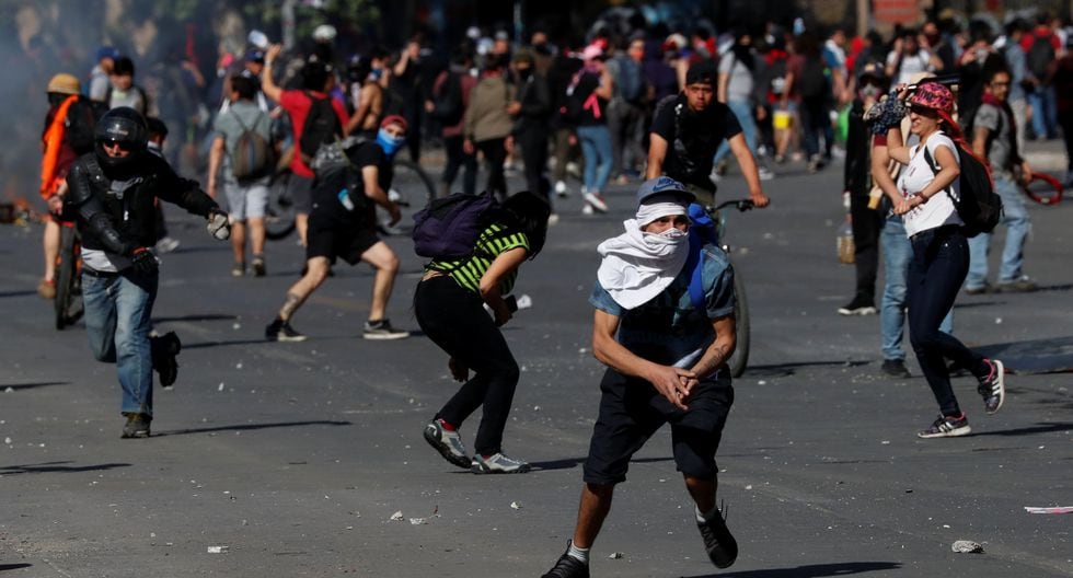 Los manifestantes que pretenden marchar a La Moneda arrojan piedras contra la policía. (REUTERS/Henry Romero).